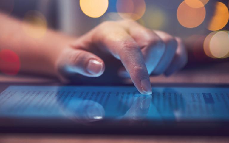 Woman reading online news on digital tablet
